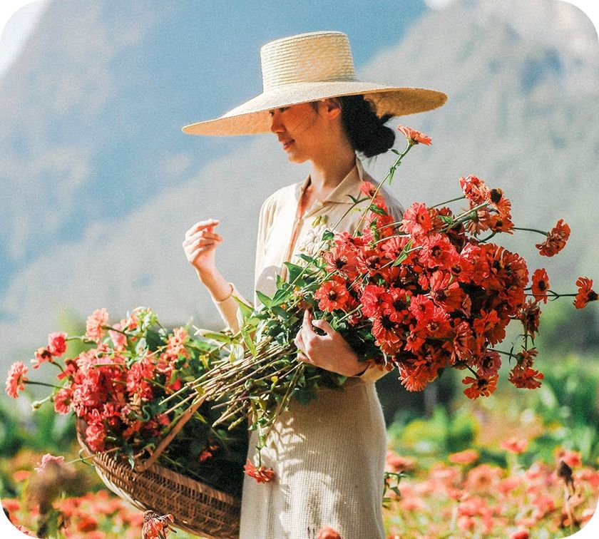 A woman holding an armful of fresh-cut flowers